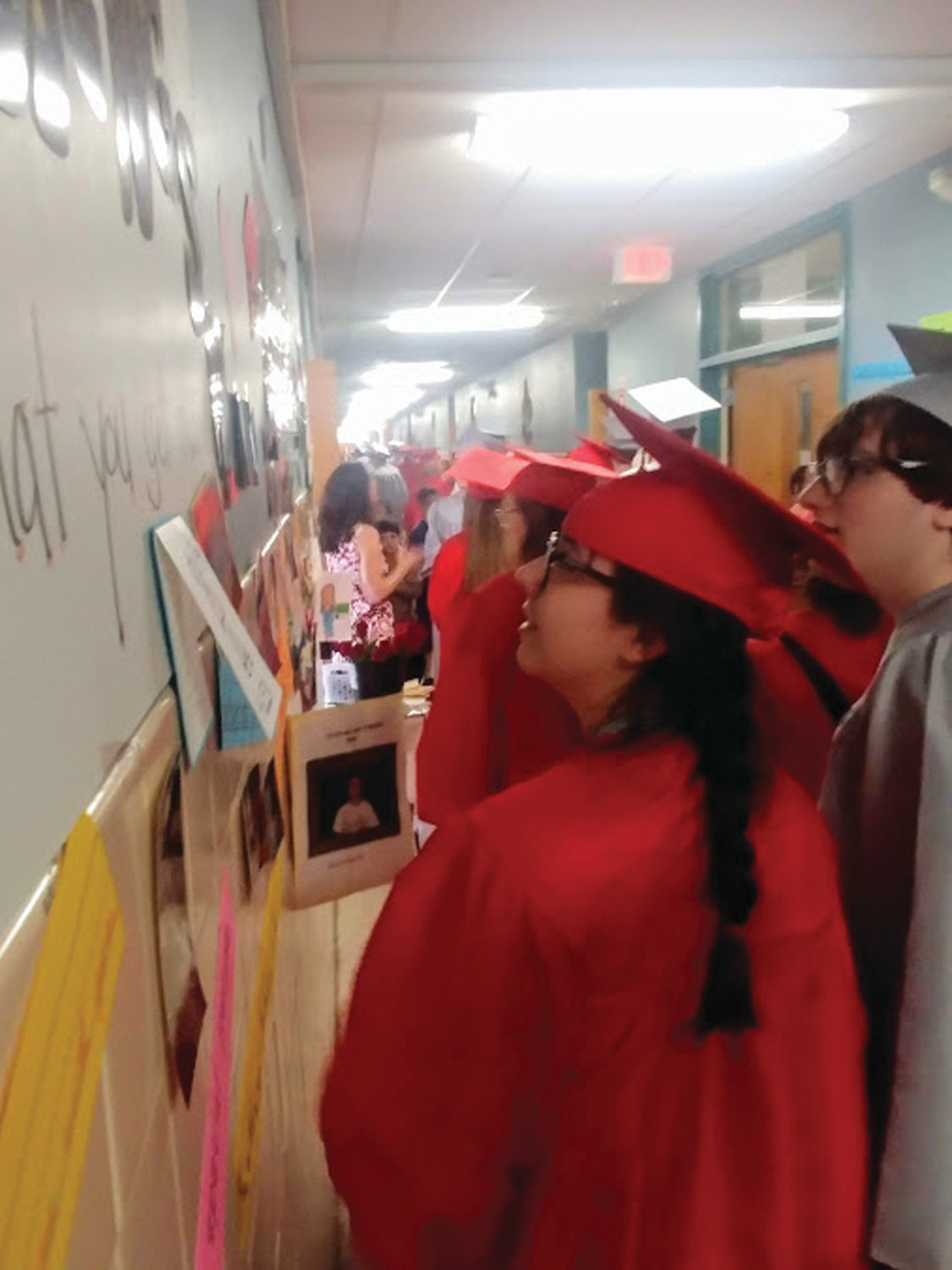 FOND MEMORIES: Ariana Deal and Nicholas Notarianni look through the photos and classwork posted on the walls of third-grade teacher Lisa Davis’ hallway, where she showcased their work, notes and photographs from many years ago.